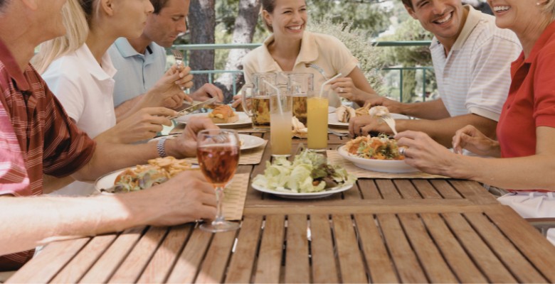 imagen de familia disfrutando en mesa de jardín limpia y cuidada