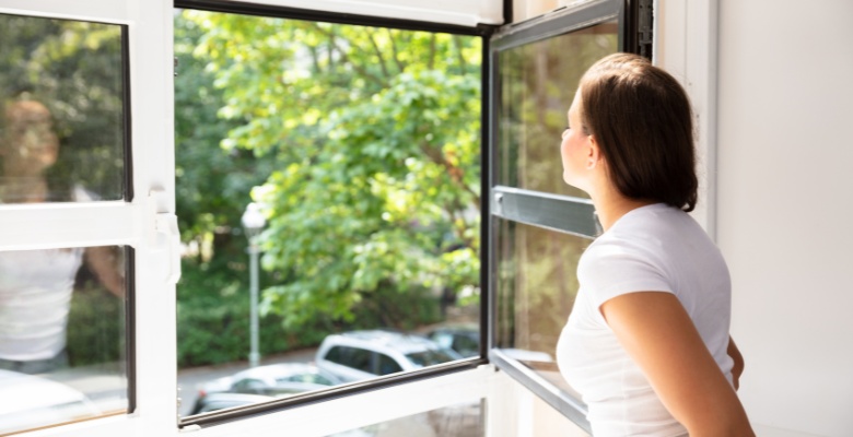 mujer disfrutando de ventanas limpias en verano